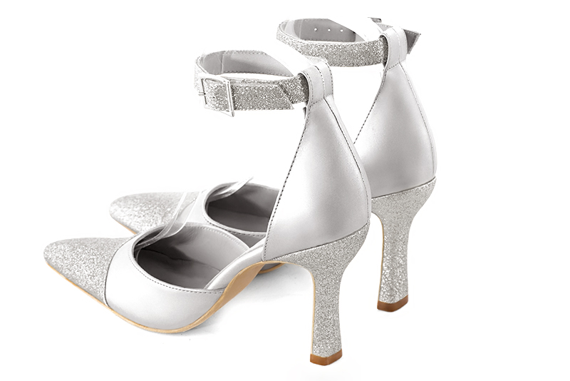Light silver women's open side shoes, with a strap around the ankle. Tapered toe. Very high spool heels. Rear view - Florence KOOIJMAN